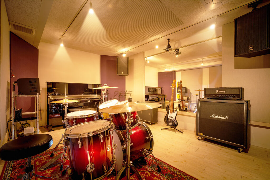 仙台市青葉区一番町の音楽教室Ammyにて貸し出し可能な防音室、Aスタジオ。ドラム、アンプ、ピアノが設置してあります。